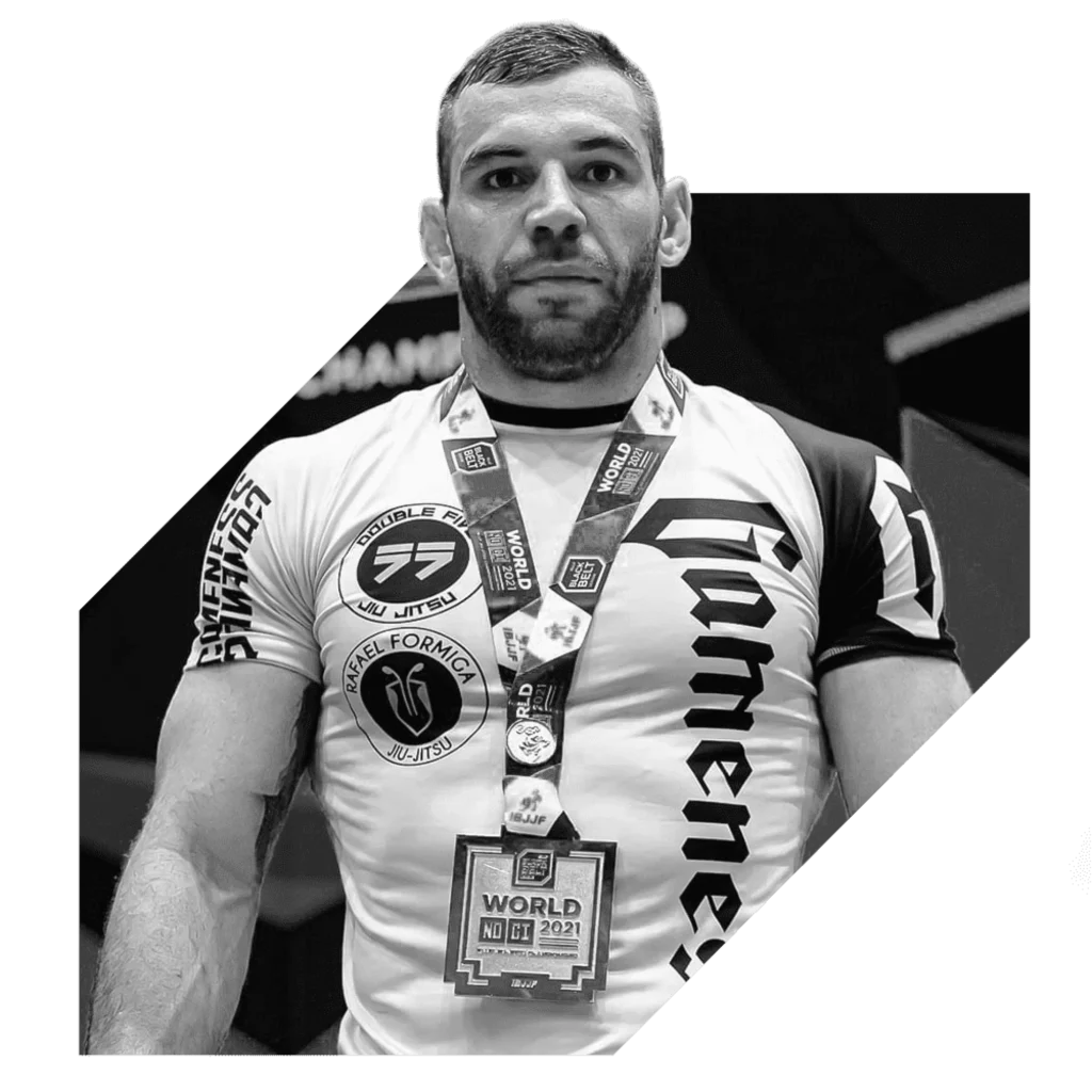 Professor Pedro Rocha wearing a Jiu-Jitsu gi and competition medals