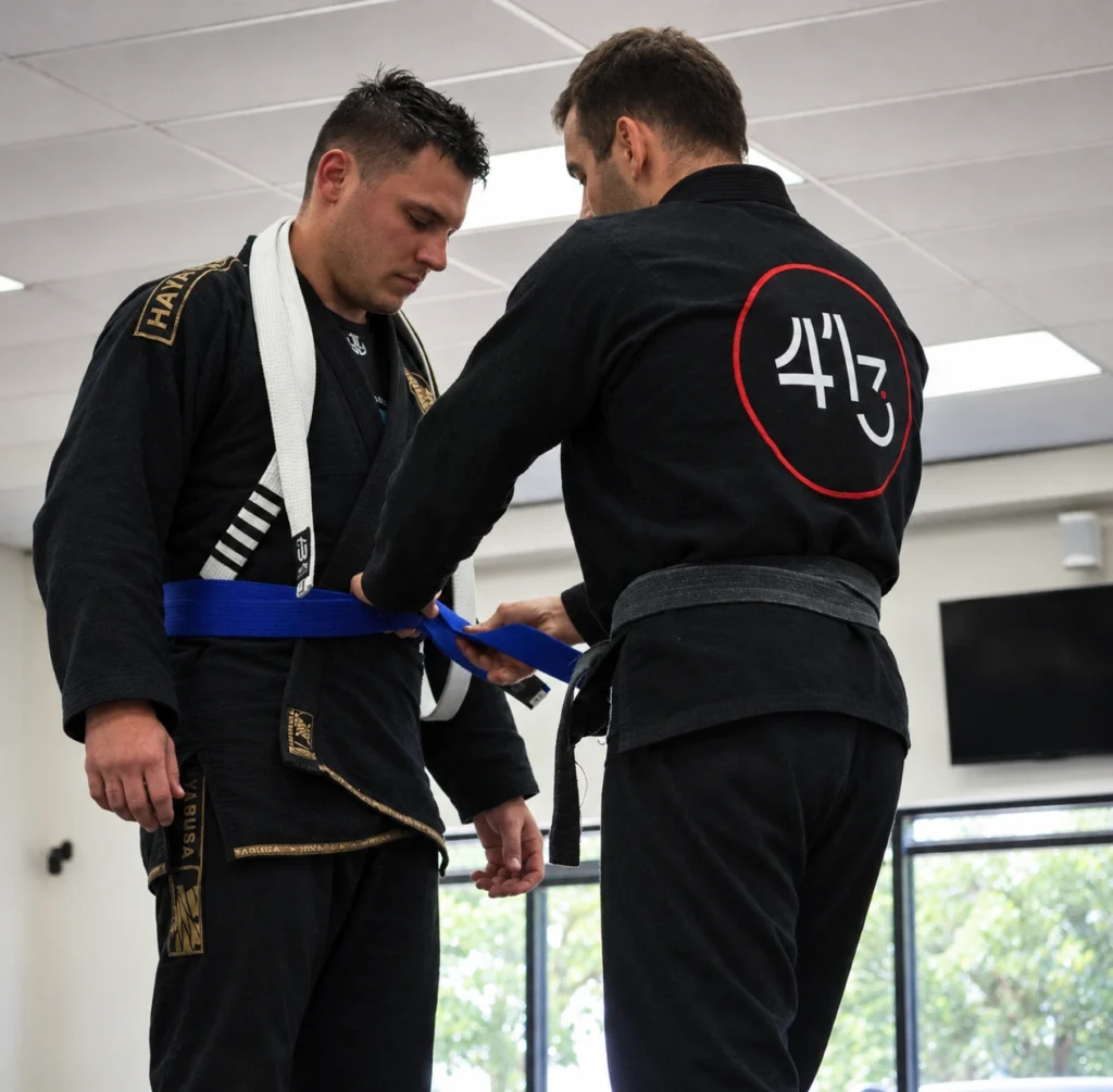 Adult student and instructor during a belt presentation at 413 Jiu-Jitsu